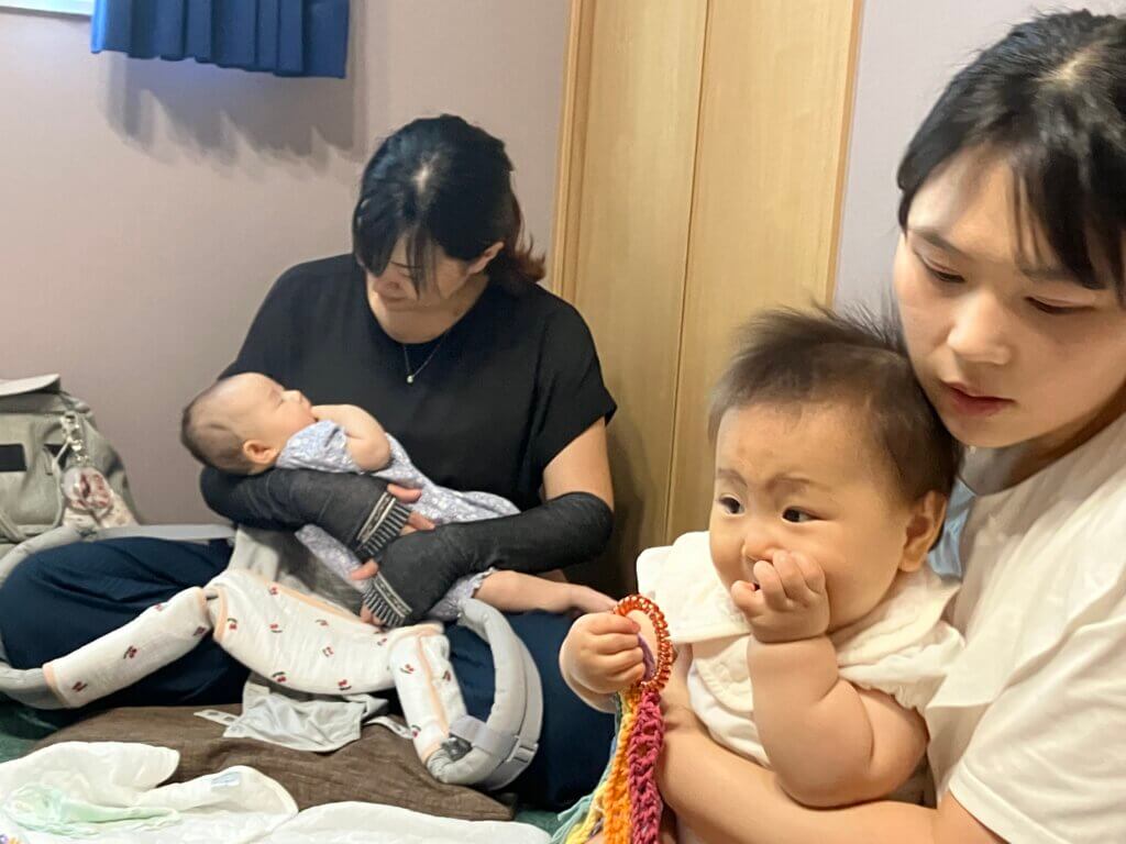 赤ちゃんを膝にのせた母親が2組