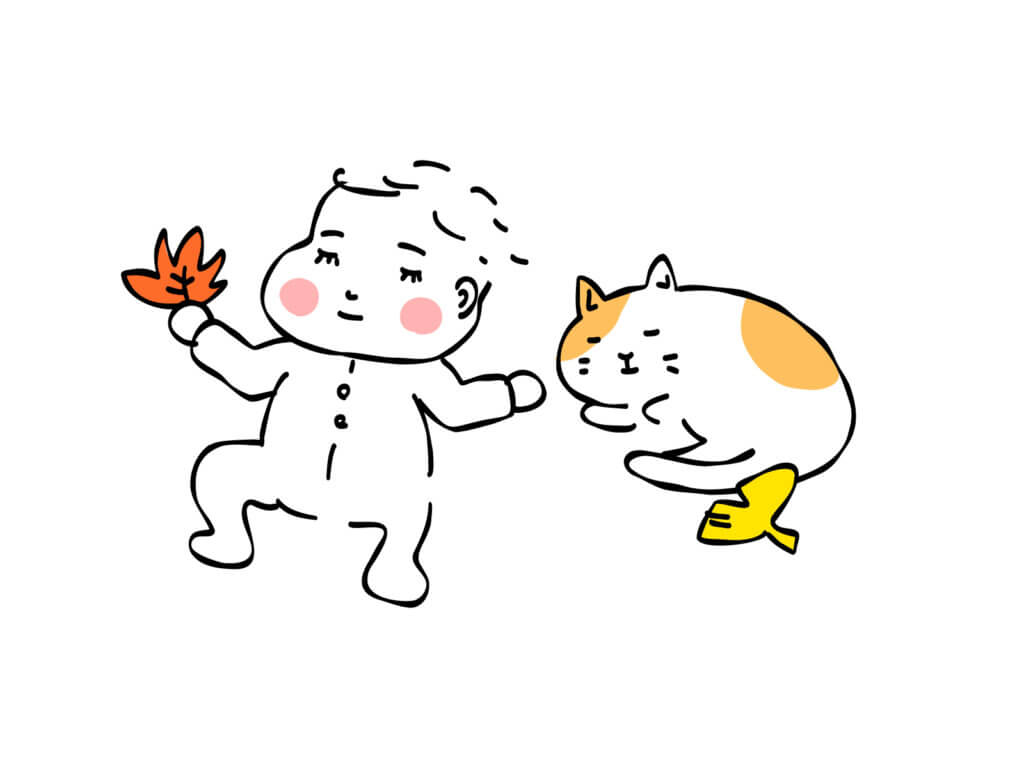落ち葉を持つ赤ちゃんとねこ